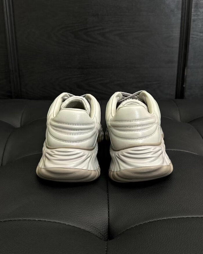 Scarpe sportive bianche con supporto ergonomico e design moderno, viste da dietro.