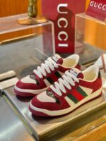 Scarpe Gucci in suede bordeaux, dettagli di lusso con logo iconico e design moderno elegante.