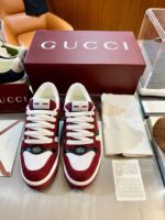 Sneakers Gucci Bordeaux in stile elegante, display di lusso in un negozio raffinato.