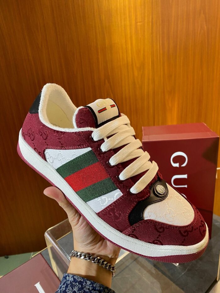 Sneaker di lusso bordeaux con strisce verdi e bianche, dettaglio esclusivo, box di design elegante.