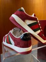 Scarpe sneakers Gucci burgundy con dettagli verde e rosso, stile lussuoso e moderno.