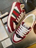 Sneakers rosse e bianche con strisce verdi, design elegante e stile moderno.