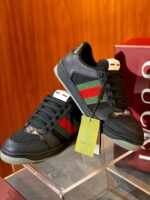 Sneakers di lusso con dettaglio rosso e verde su stand trasparente, stile elegante e moderno.
