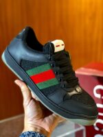 Sneaker nera elegante con dettagli verde e rosso, stile di lusso e design moderno.