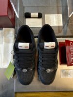 Scarpe sneakers Gucci nere di lusso con dettagli eleganti in esposizione.
