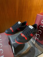 Sneaker di lusso nero e rosso con branding prestigioso su base di vetro trasparente