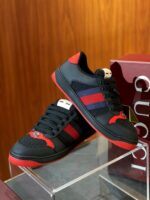 Sneakers di lusso Gucci con dettagli rossi e viola su sfondo in legno elegante.
