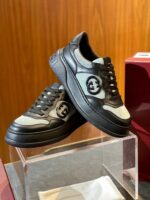 Sneakers di lusso in pelle e tessuto su stand trasparente con dettagli moderni e stile elegante.