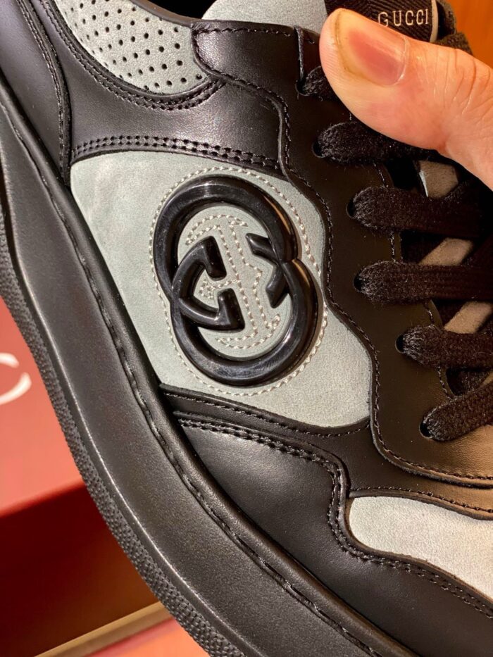 Sneaker di lusso in nero e grigio con logo grande, design minimalista e netto stile moderno.