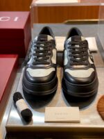 Sneakers Gucci moderni in nero e bianco con design trendy e logo distintivo.
