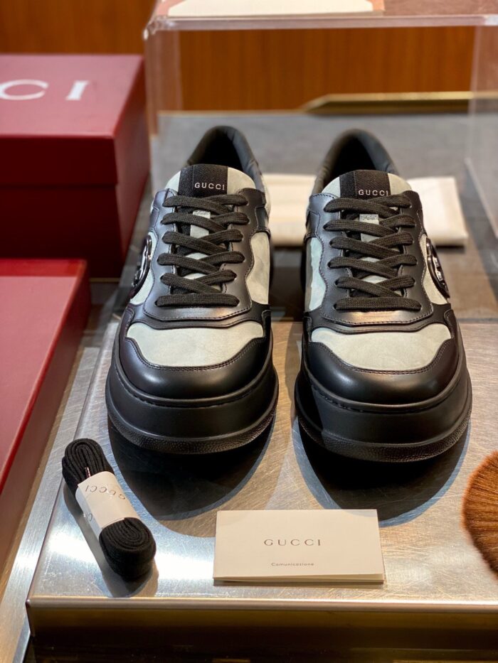 Sneakers Gucci moderni in nero e bianco con design trendy e logo distintivo.