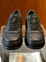 Sneakers nere in pelle elegante, design minimalista, su sfondo in legno raffinato.