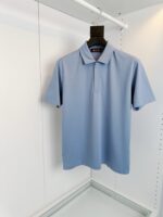 Maglietta polo azzurra pastello elegante e casual su gruccia, ideale per look estivi e raffinati.