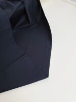 Tessuto blu navy elegante con piega perfetta, ideale per abbigliamento e design raffinato.