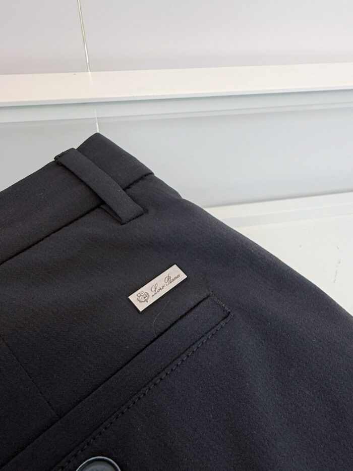 Pantaloni eleganti neri con dettaglio metallico e tessuto di alta qualità, perfetti per occasioni formali.