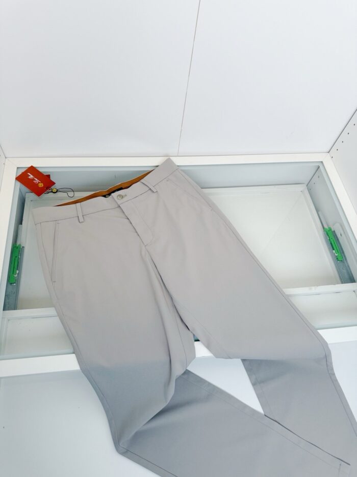 Pantaloni eleganti grigi con tag rosso, stile classico, tessuto leggero e taglia visibile.