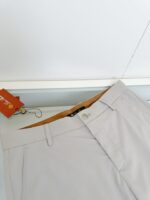 Pantaloni beige casual e eleganti con cintura e tasche in tessuto leggero.