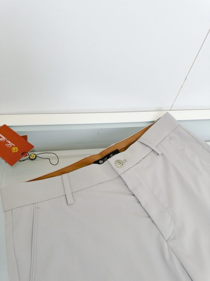 Pantaloni beige casual e eleganti con cintura e tasche in tessuto leggero.