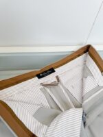 Giacca elegante con colletto marrone e interno a righe grigie, alta qualità e stile sofisticato.
