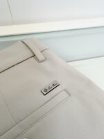 Pantaloni beige eleganti con dettaglio in metallo, stile raffinato e taglio sartoriale.