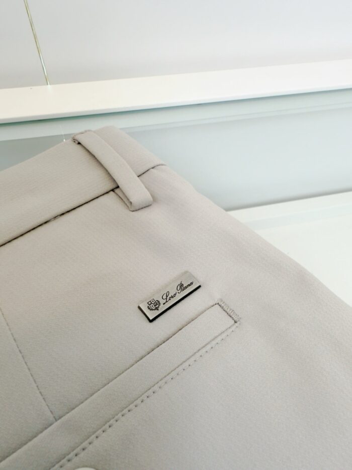 Pantaloni beige eleganti con dettaglio in metallo, stile raffinato e taglio sartoriale.