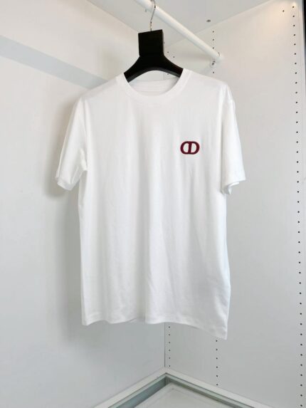 Maglietta bianca minimalista con logo rosso, stile versatile e fashion, su appendiabiti nero.