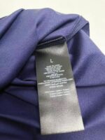Etichetta di abbigliamento viola con dettagli di cura e tag S, made in China.