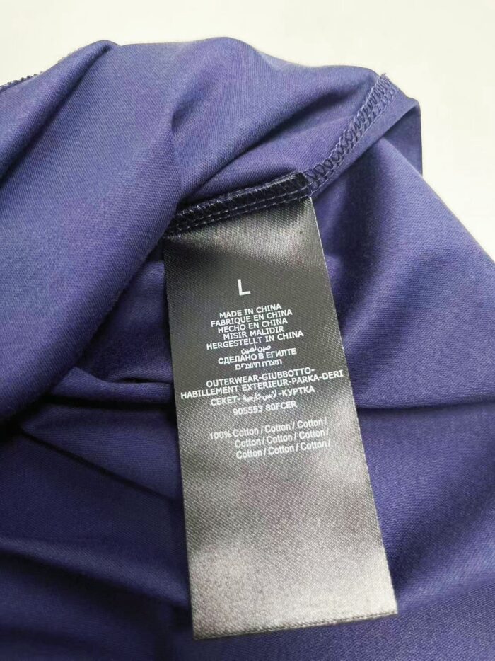 Etichetta di abbigliamento viola con dettagli di cura e tag S, made in China.