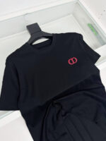 T-shirt nera con logo interlocking rosso, casual e moderno, perfetta per ogni occasione.