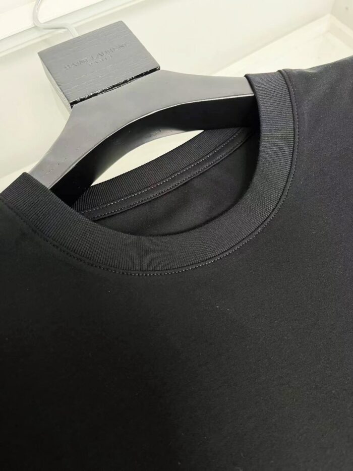 Maglietta nera in cotone con collo a coste, semplice ed elegante, ideale per ogni look quotidiano.