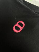 Logo rosa su maglietta nera, design moderno e elegante, stile minimalista e di tendenza.