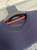 Maglietta navy blue con dettaglio arancione interno, stile minimalista e qualità premium.