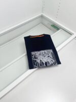 Maglietta nera con grafica bianca, stile minimalista e dettagli colorati, ideale per look moderni.