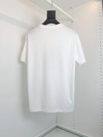 T-shirt bianca classica, semplice ed elegante, appesa su appendino moderno per stile minimalista.