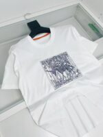 Maglietta bianca con grafica artistica in blu e nero, maniche corte e scollo rotondo.