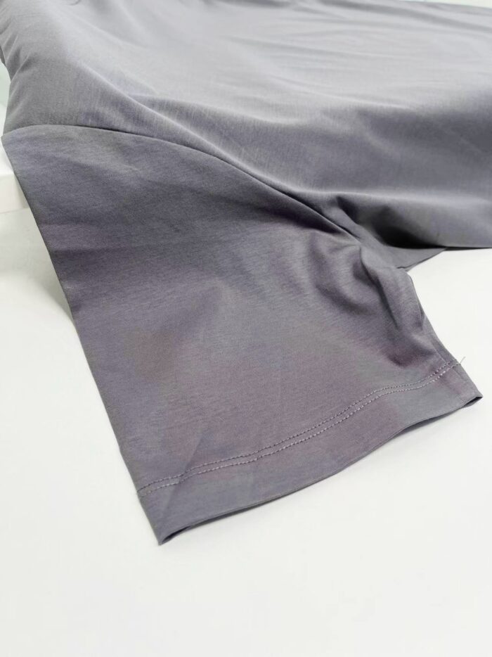 Tessuto grigio leggero con finitura satinata, ideale per abbigliamento casual e versatile.