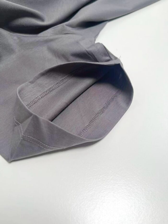 Cappuccio di camicia grigia, tessuto morbido con cuciture precise e stile elegante.