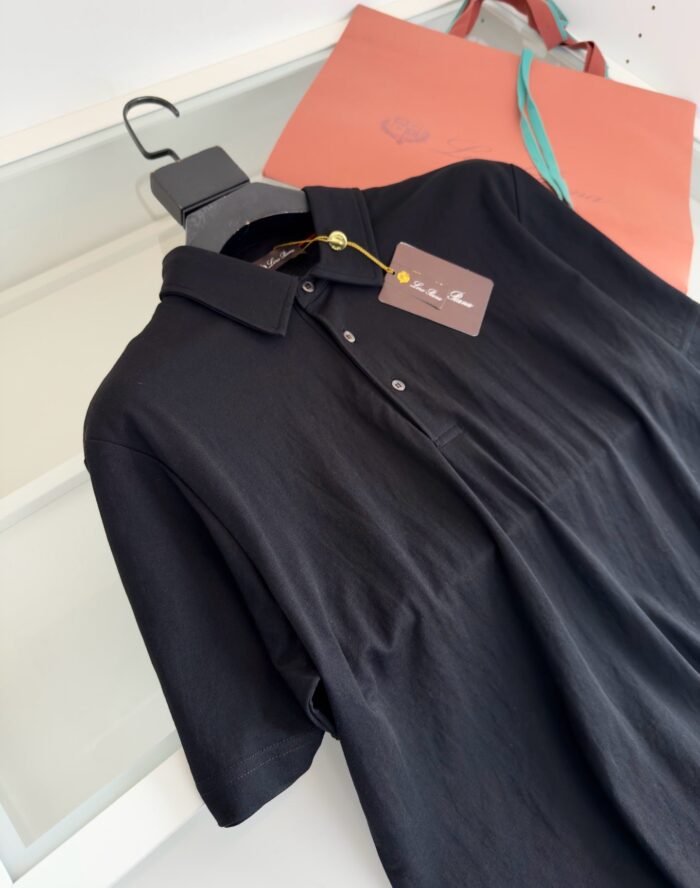 Maglietta polo nera elegante con borsa corallo, stile minimalista e shopping di moda.