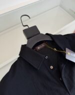Camicia polo nera elegante, bottoni contrasto, tessuto morbido, stile raffinato e di alta qualità.