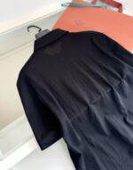Maglietta polo nera elegante con dettagli di lusso, sfondo minimalista, accessori sofisticati.