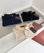 Magliette polo eleganti su vetrina, dettagli curati, colori neutri e atmosfera raffinata.