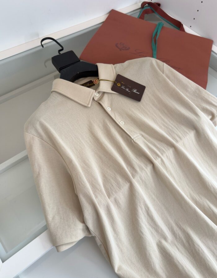 Set di moda con camicia beige e borsa in pelle a tracolla marrone con dettaglio verde.