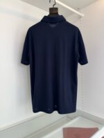Maglietta polo navy elegante su supporto, dettaglio di alta qualità e stile minimalista