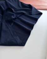 Maglietta navy blu minimalista su sfondo bianco con dettagli eleganti e contrasto in tessuto pesca.
