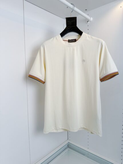 T-shirt bianca casual con dettagli a righe color terracotta e logo discreto elegante.