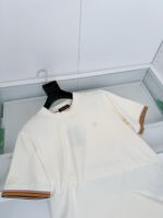 T-shirt bianca con dettagli colorati e logo minimale, perfetta per stile casual e moderno.