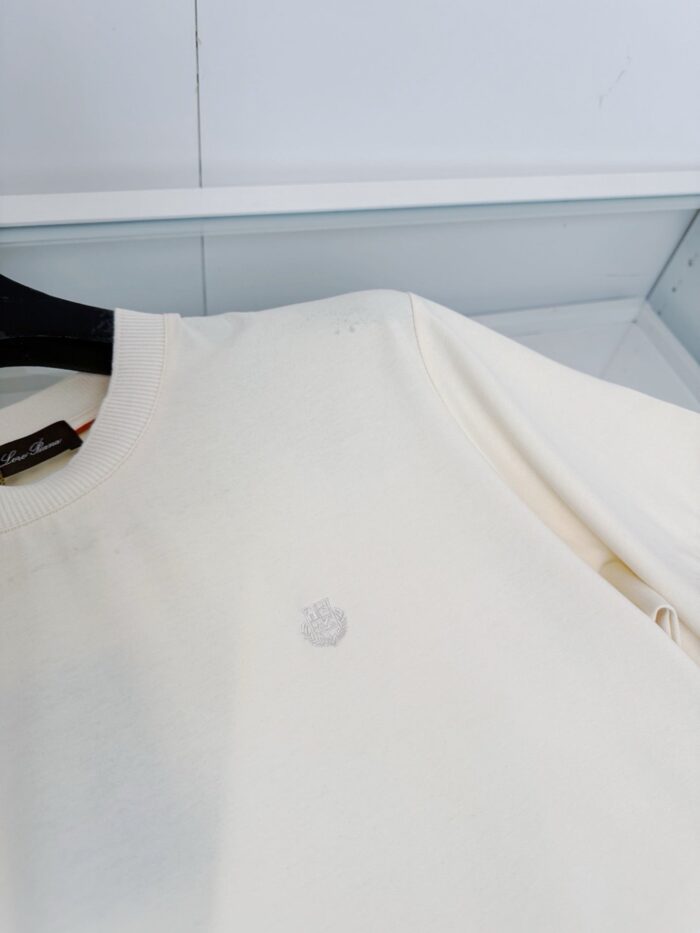 Camicia bianca minimalista con logo discreto, stile semplice e versatile per ogni look casual.