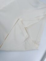 Lino bianco e elegante con pieghe impeccabili, ideale per biancheria da letto raffinata.