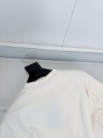 Camicia bianca minimalista su appendiabiti moderno, stile semplice ed elegante per look casual.