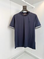 T-shirt navy con logo discreto e strisce eleganti sui maniche, stile casual e moderno.